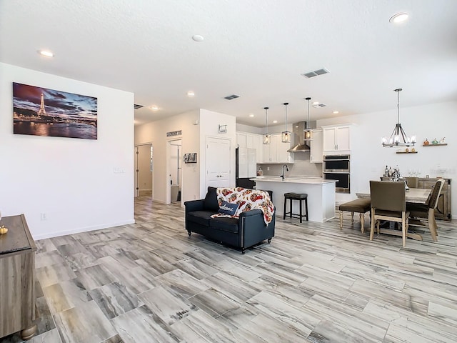 living room featuring a notable chandelier and sink