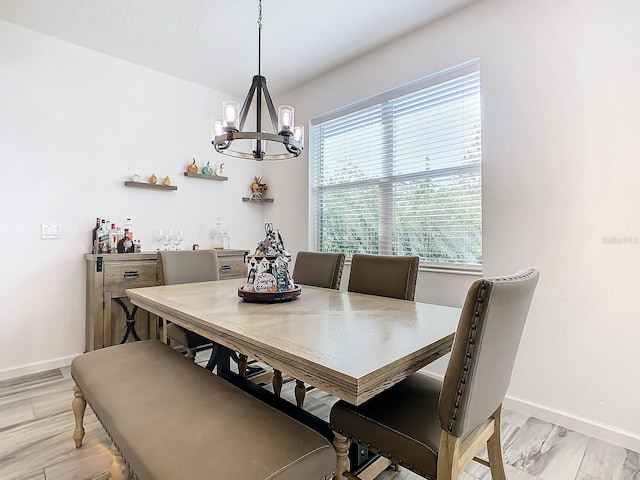 dining room with light hardwood / wood-style floors and an inviting chandelier