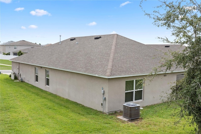 rear view of house featuring a yard and central AC