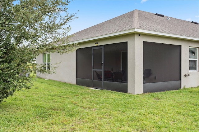 rear view of house with a sunroom and a yard