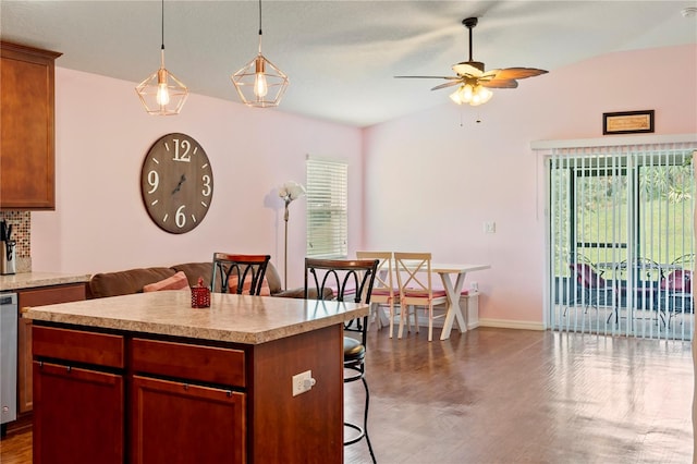 kitchen featuring a kitchen island, plenty of natural light, decorative light fixtures, and dark hardwood / wood-style floors