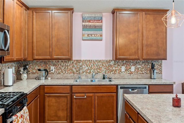 kitchen with appliances with stainless steel finishes, hanging light fixtures, sink, and tasteful backsplash