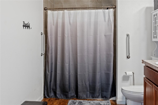 bathroom with wood-type flooring, a shower with shower curtain, vanity, and toilet