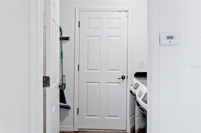 laundry room with hardwood / wood-style flooring and washer and clothes dryer