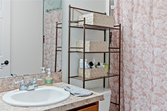 bathroom with a shower with curtain, vanity, and toilet