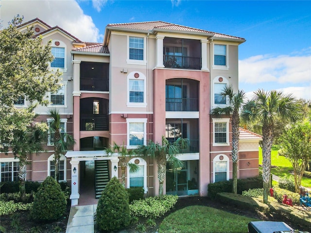 view of front of property with a balcony and a front lawn