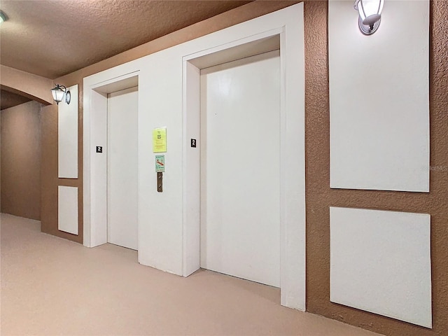 8298 Portofino Dr Unit 202, Davenport, FL 33896 - hall featuring elevator, light colored carpet, and a textured ceiling