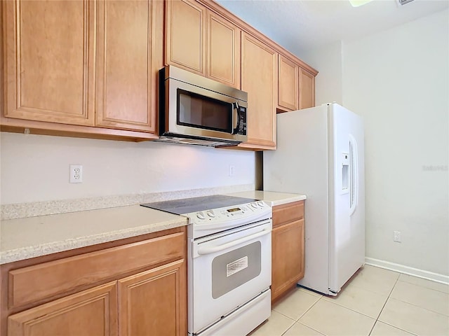 8298 Portofino Dr Unit 202, Davenport, FL 33896 - kitchen featuring white appliances, light countertops, light tile patterned floors, and baseboards