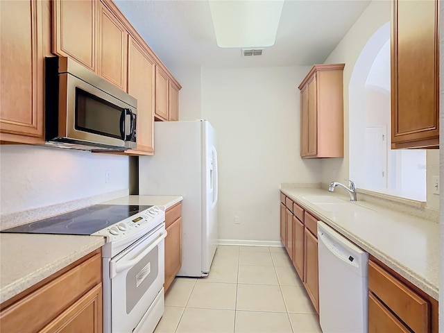 kitchen featuring white appliances, light tile patterned floors, and sink