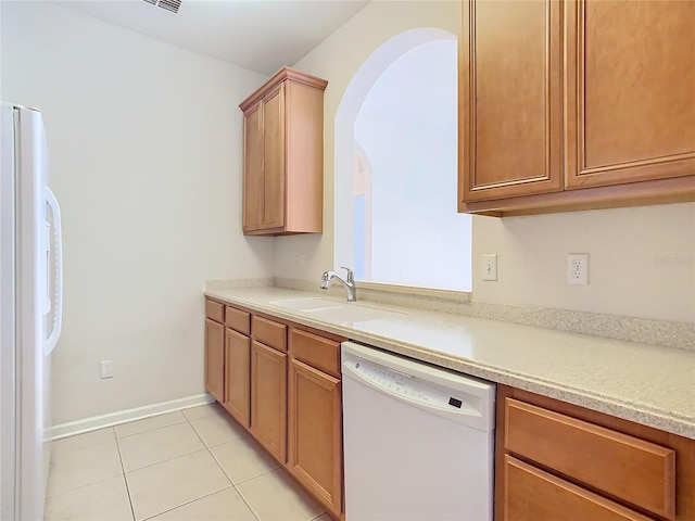 kitchen featuring white appliances, light tile patterned floors, and sink