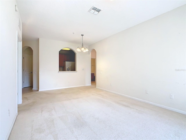 carpeted empty room with a chandelier