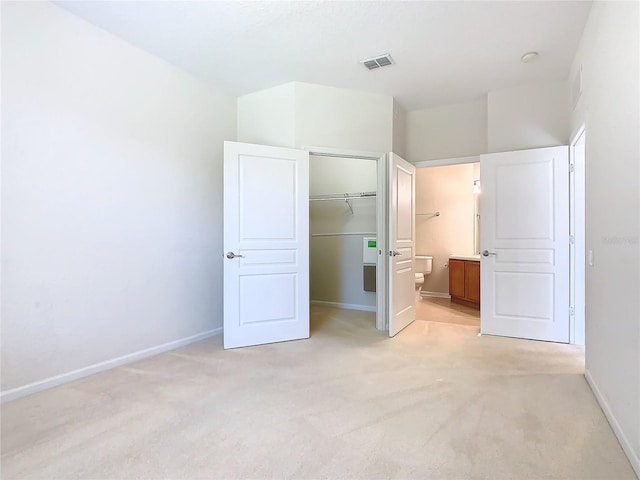 8298 Portofino Dr Unit 202, Davenport, FL 33896 - unfurnished bedroom featuring baseboards, light carpet, a closet, ensuite bath, and a spacious closet