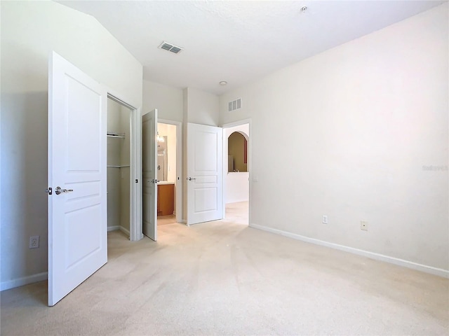 unfurnished bedroom featuring light colored carpet and a closet