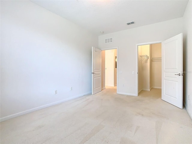 8298 Portofino Dr Unit 202, Davenport, FL 33896 - unfurnished bedroom with light carpet, baseboards, a spacious closet, and a closet