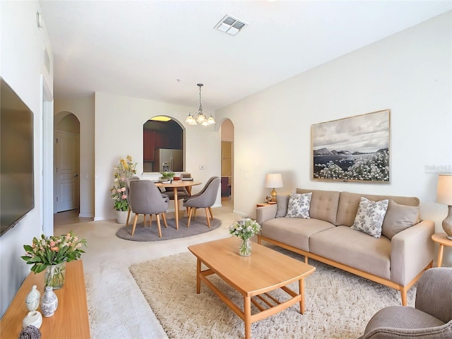 carpeted living room featuring a chandelier