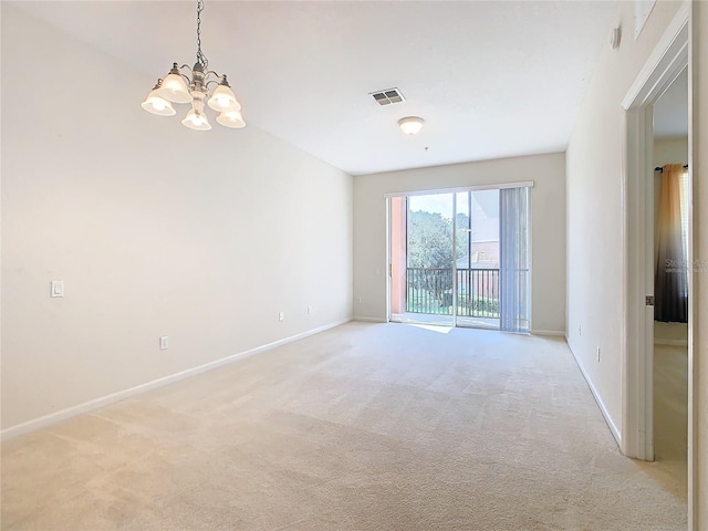 spare room with a chandelier and light carpet