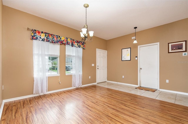 unfurnished room featuring light hardwood / wood-style floors and an inviting chandelier