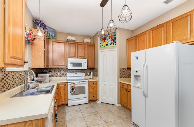 kitchen featuring backsplash, white appliances, sink, light tile patterned floors, and hanging light fixtures