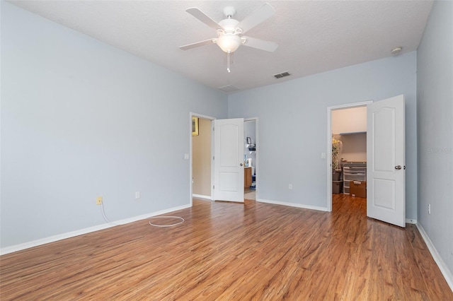 unfurnished bedroom with ceiling fan, a textured ceiling, and light wood-type flooring