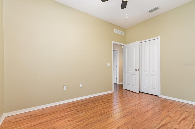 unfurnished bedroom featuring ceiling fan, a closet, and light wood-type flooring