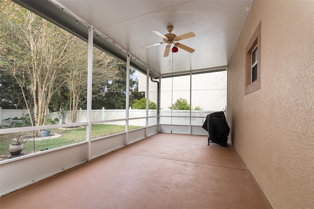 unfurnished sunroom with ceiling fan