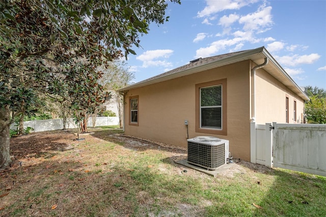 view of side of property featuring a lawn and cooling unit