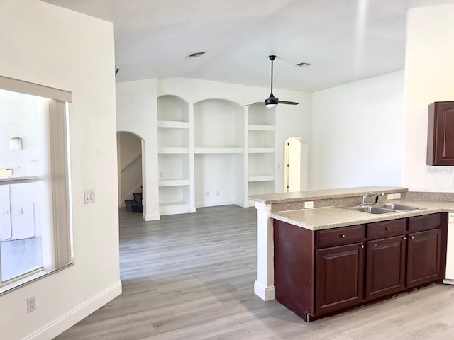 kitchen with built in shelves, ceiling fan, light hardwood / wood-style flooring, and sink