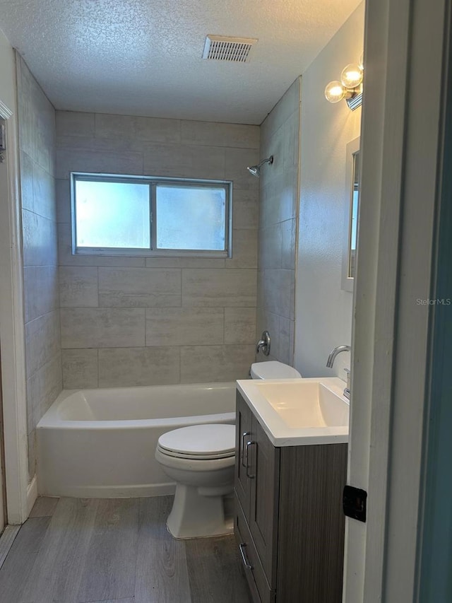 full bathroom featuring hardwood / wood-style floors, vanity, toilet, and a textured ceiling