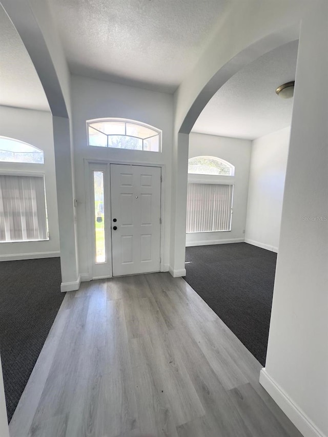 entryway with light wood-type flooring and a textured ceiling