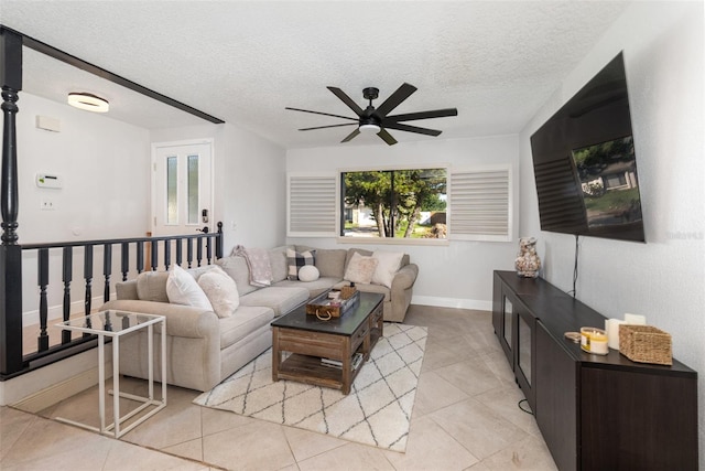 tiled living room with ceiling fan and a textured ceiling