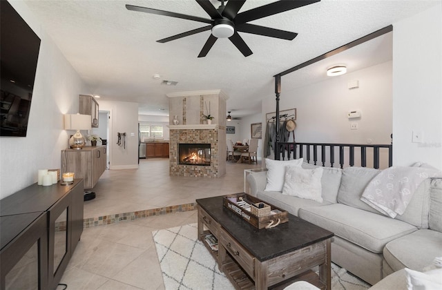 tiled living room with a fireplace, a textured ceiling, and ceiling fan