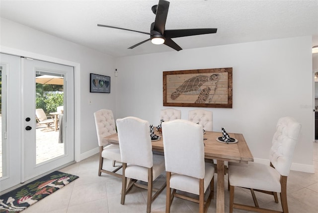 tiled dining area with ceiling fan and a textured ceiling