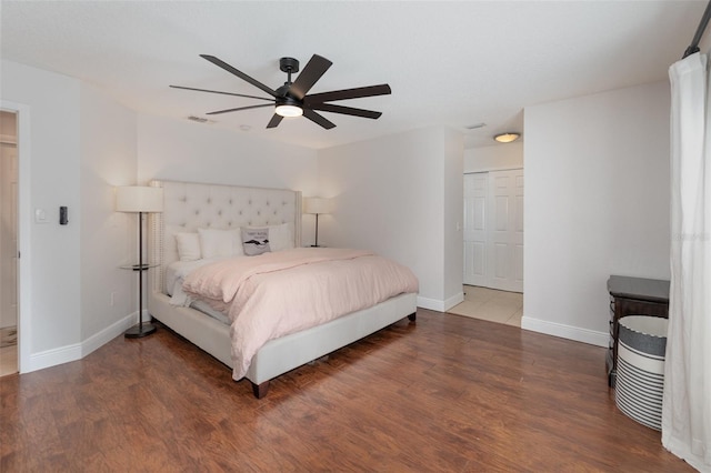 bedroom featuring ceiling fan, dark hardwood / wood-style flooring, and a closet