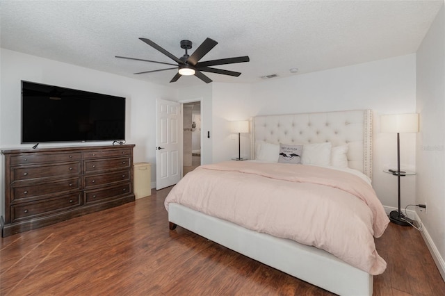 bedroom with a textured ceiling, dark hardwood / wood-style floors, and ceiling fan