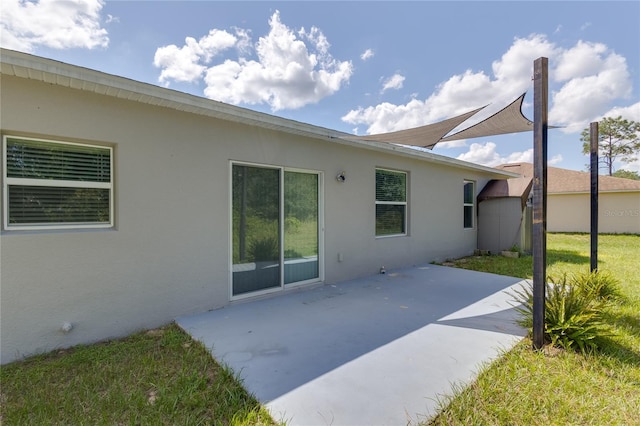 rear view of house with a lawn and a patio area