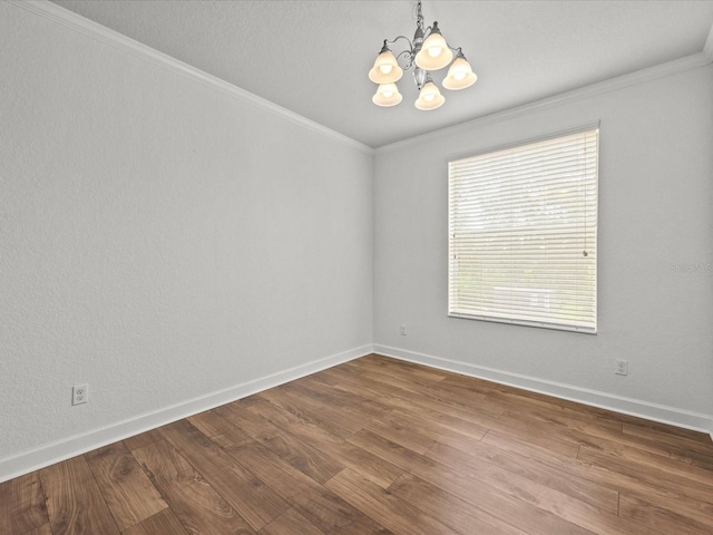 unfurnished room with a chandelier, hardwood / wood-style floors, and ornamental molding