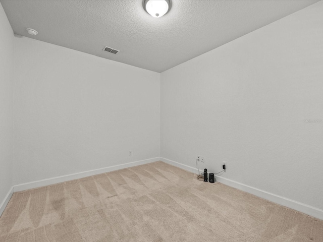 carpeted spare room with a textured ceiling