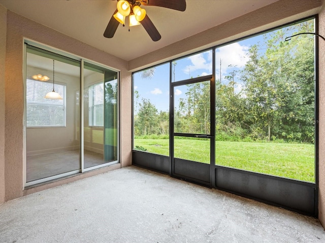 unfurnished sunroom featuring ceiling fan