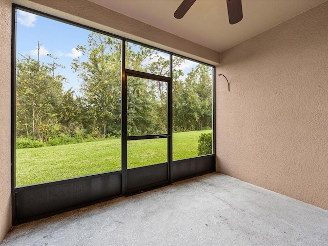 unfurnished sunroom featuring a wealth of natural light and ceiling fan