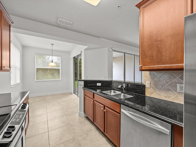 kitchen with tasteful backsplash, sink, decorative light fixtures, dark stone countertops, and dishwasher