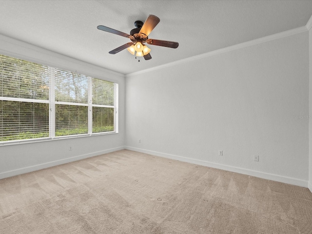 carpeted spare room with crown molding and ceiling fan