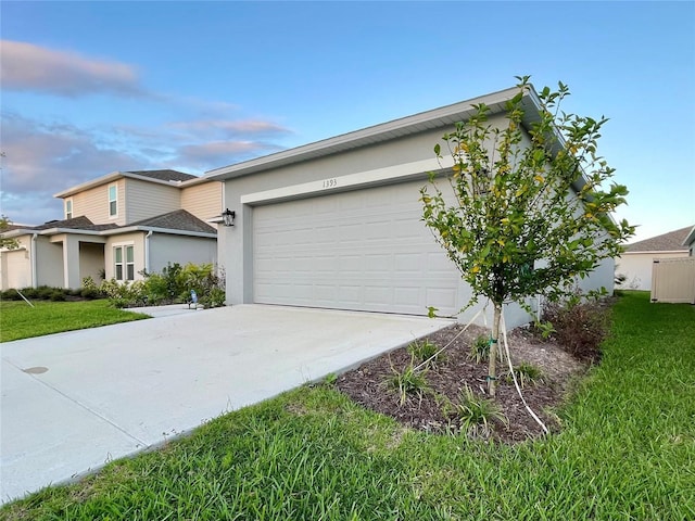 1393 Asher Mason Ave, Kissimmee, FL 34744 - view of front of property with stucco siding, driveway, an attached garage, and a front yard