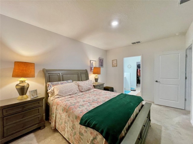 carpeted bedroom with a closet, a walk in closet, and a textured ceiling