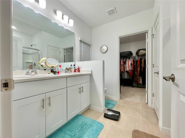 bathroom featuring vanity, toilet, a textured ceiling, and tile patterned floors