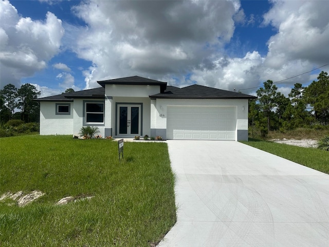 prairie-style house with a garage and a front lawn