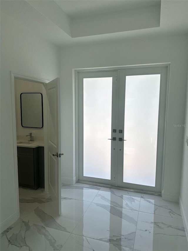 interior space with a raised ceiling, french doors, and a wealth of natural light