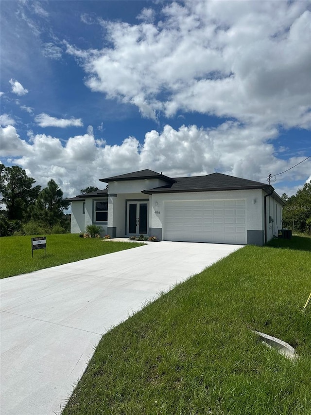 view of front facade featuring a front yard, a garage, and central air condition unit