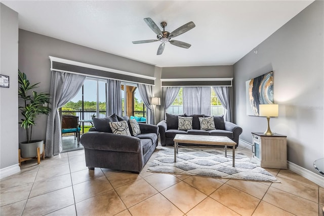 tiled living room featuring a ceiling fan and baseboards