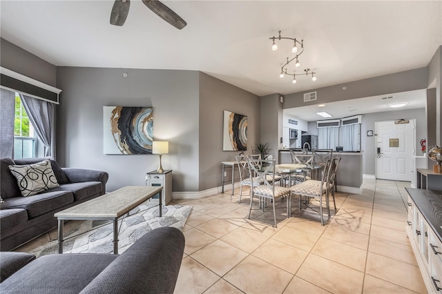 living area featuring ceiling fan, baseboards, visible vents, and light tile patterned floors