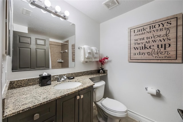 bathroom with vanity, a textured ceiling, and toilet